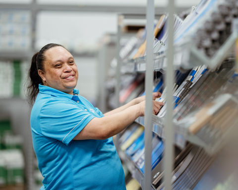 Smiling Warehouse Stationery worker arranging products, Warehouse Stationery careers opportunity displayed