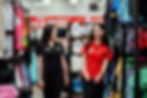 Two women smiling, walking through clothing racks, The Warehouse careers.